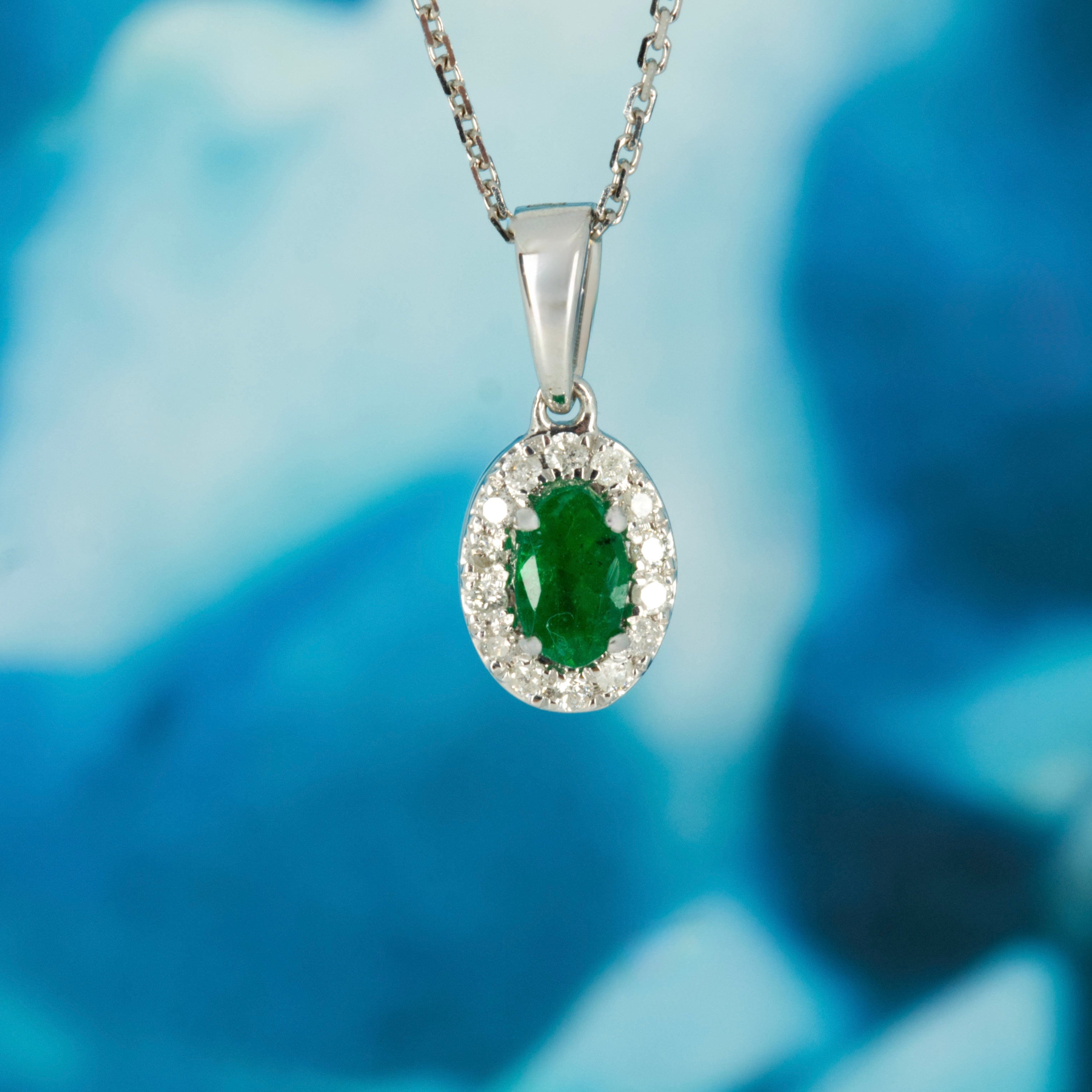 9ct White Gold Oval Cut Emerald & Round Brilliant Cut Diamond Halo Cluster Pendant & Chain