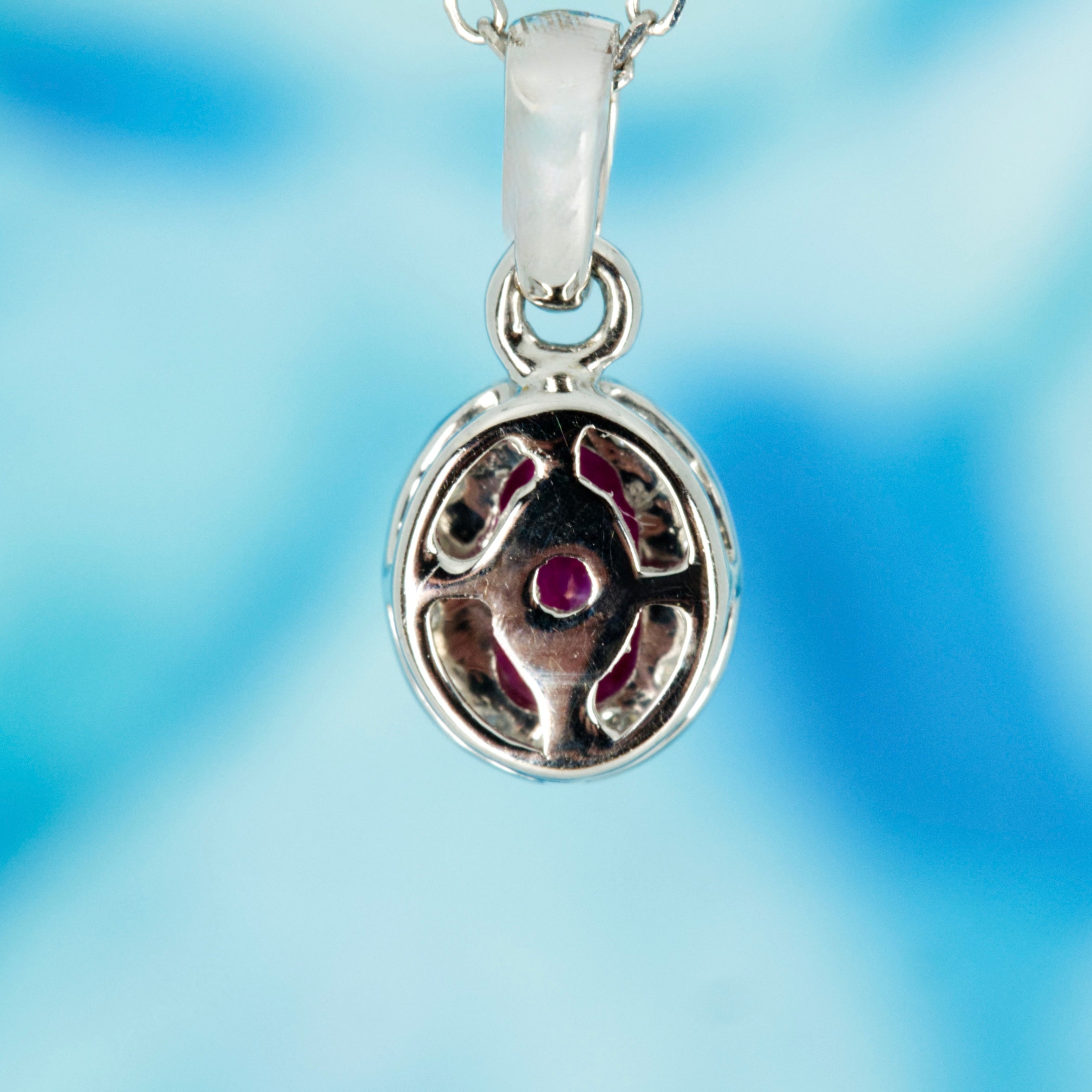 18ct White Gold Oval Cut Ruby & Round Brilliant Cut Diamond Halo Cluster Pendant & Chain