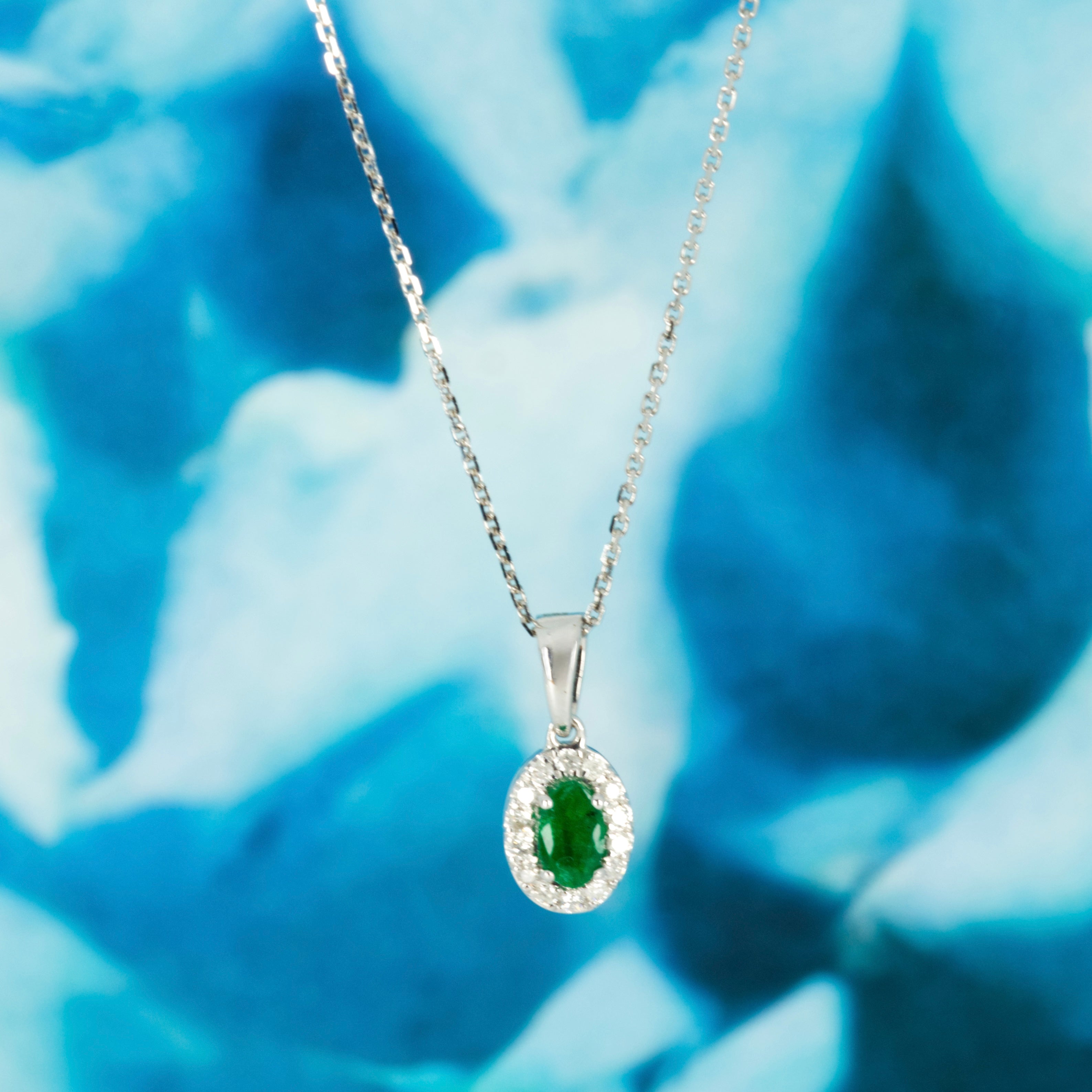 9ct White Gold Oval Cut Emerald & Round Brilliant Cut Diamond Halo Cluster Pendant & Chain